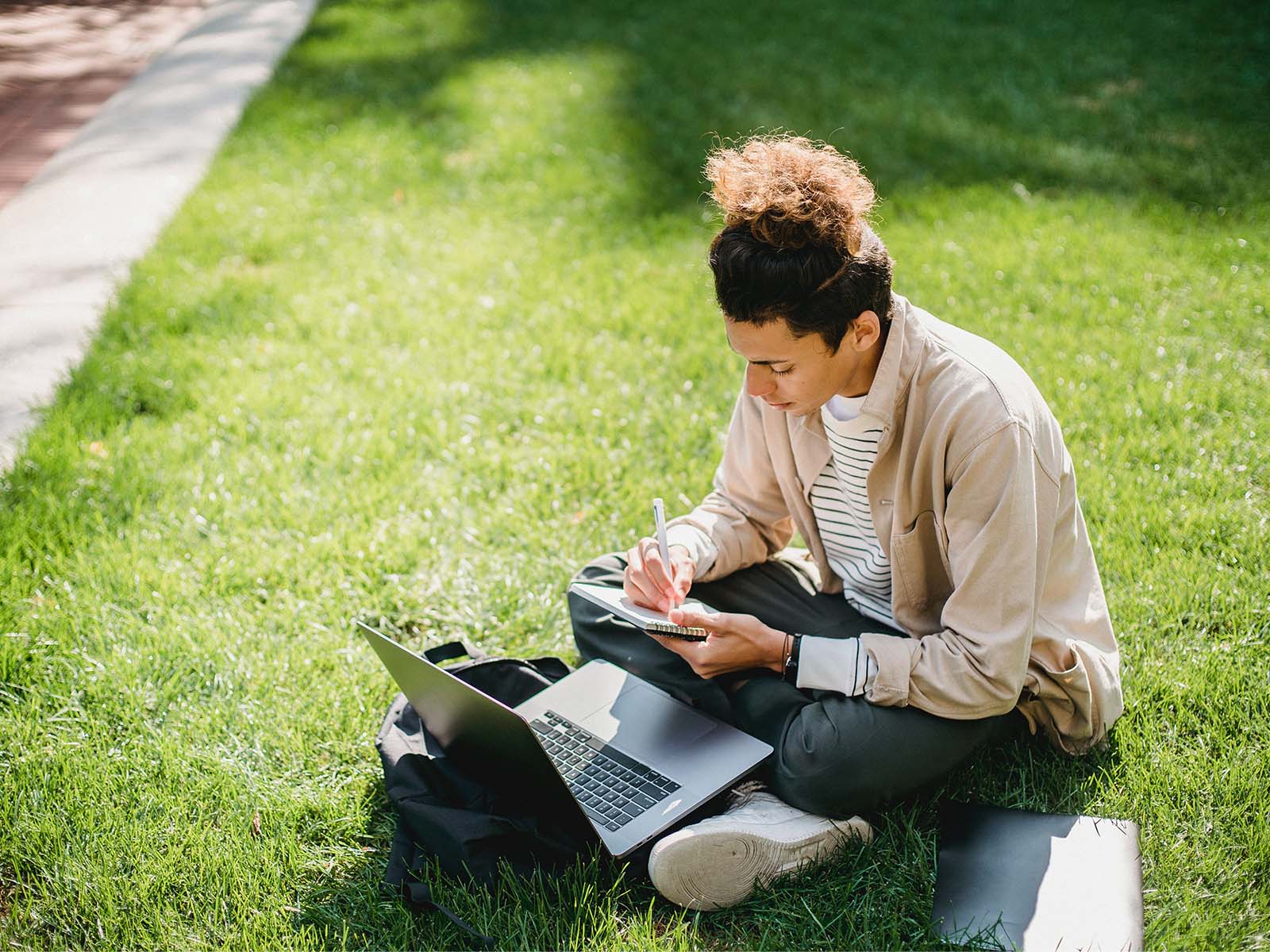 Warren-UC-International-Private-College-Counselling-Blog-post-University-Researching-High-School-Student-sitting-in-grass-working-on-laptop-Pexels-Armin-Rimoldi