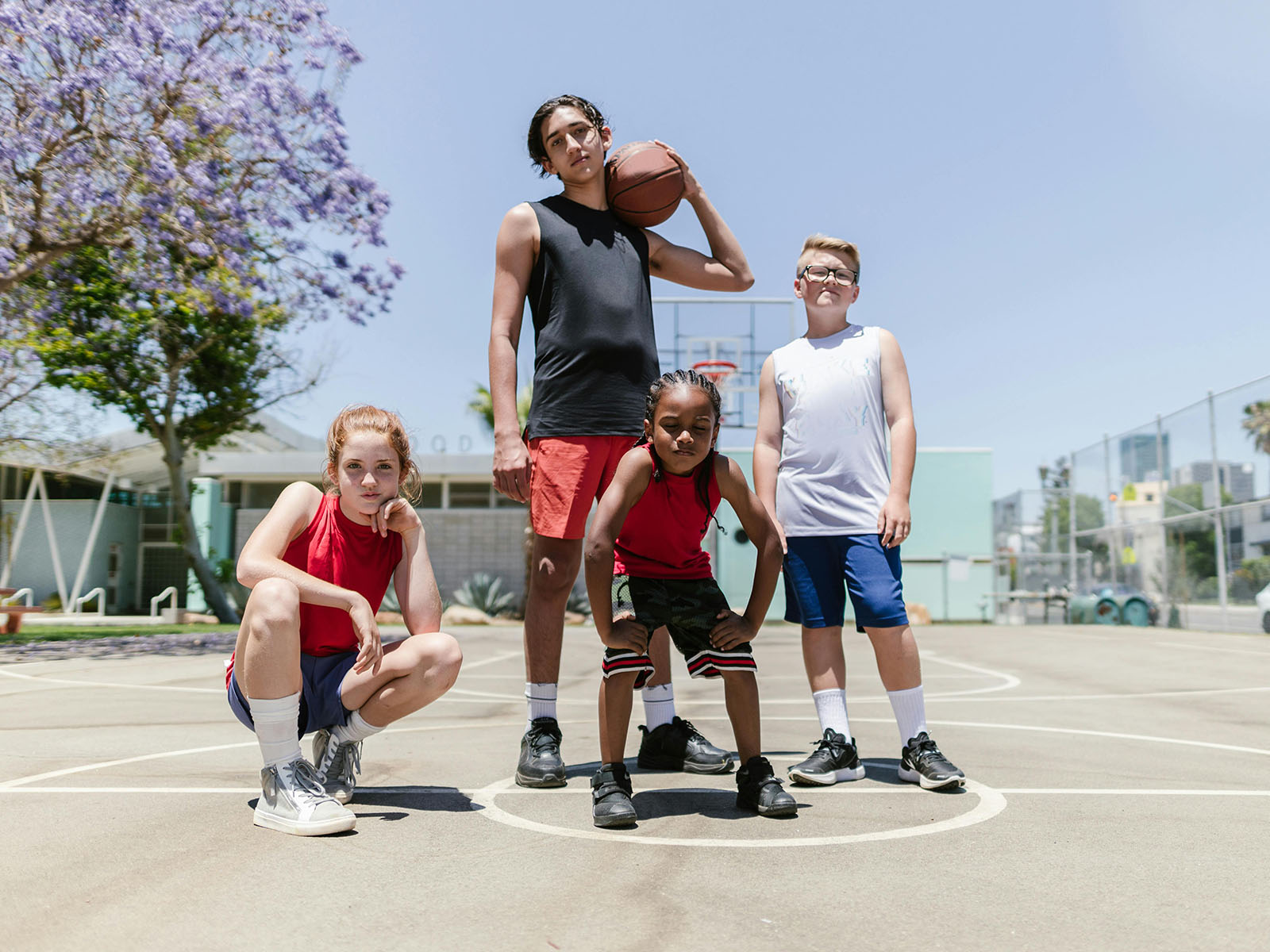 Warren UC - International Private College Consulting - Activities- How Important Are They? blog post - four children and teens posing on basketball court with ball - Pexels RDNE Stock