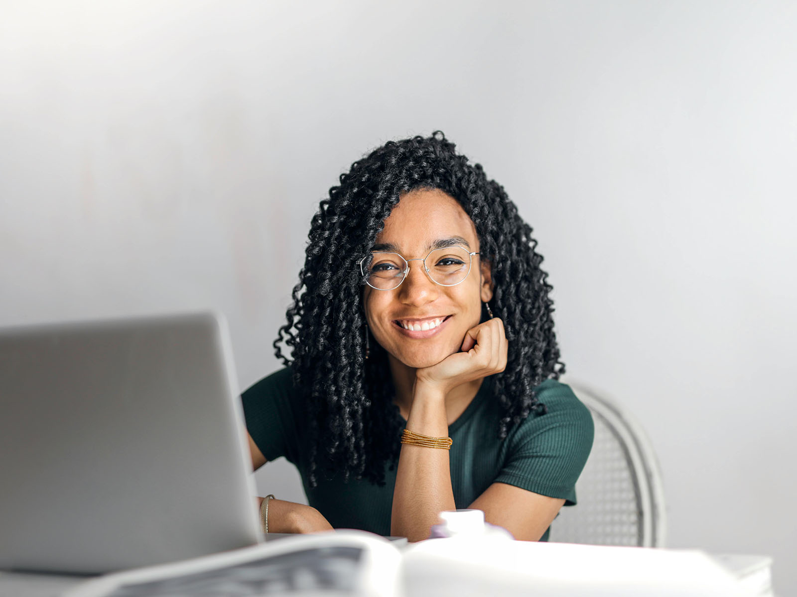 Warren UC - International Private College Consulting - Activities- Is There A Formula? blog post - young woman at laptop looking at camera with big smile - Pexels Andrea Piacquadio