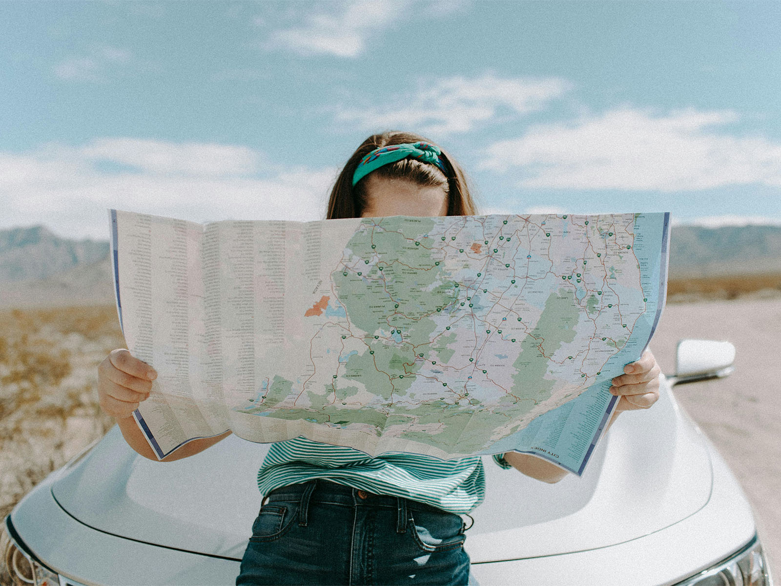 Warren UC - Private International College Consulting - Selecting your stops- Advice for university visit planning blog post - Woman behind road map leaning on car hood - Pexels Leah Newhouse