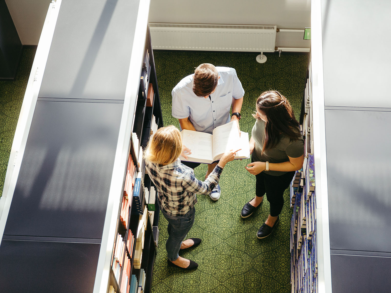 Warren UC - Private International College Consulting - CC Webinar - Curriculum Choices - Three people in library pictured from above - Freepik