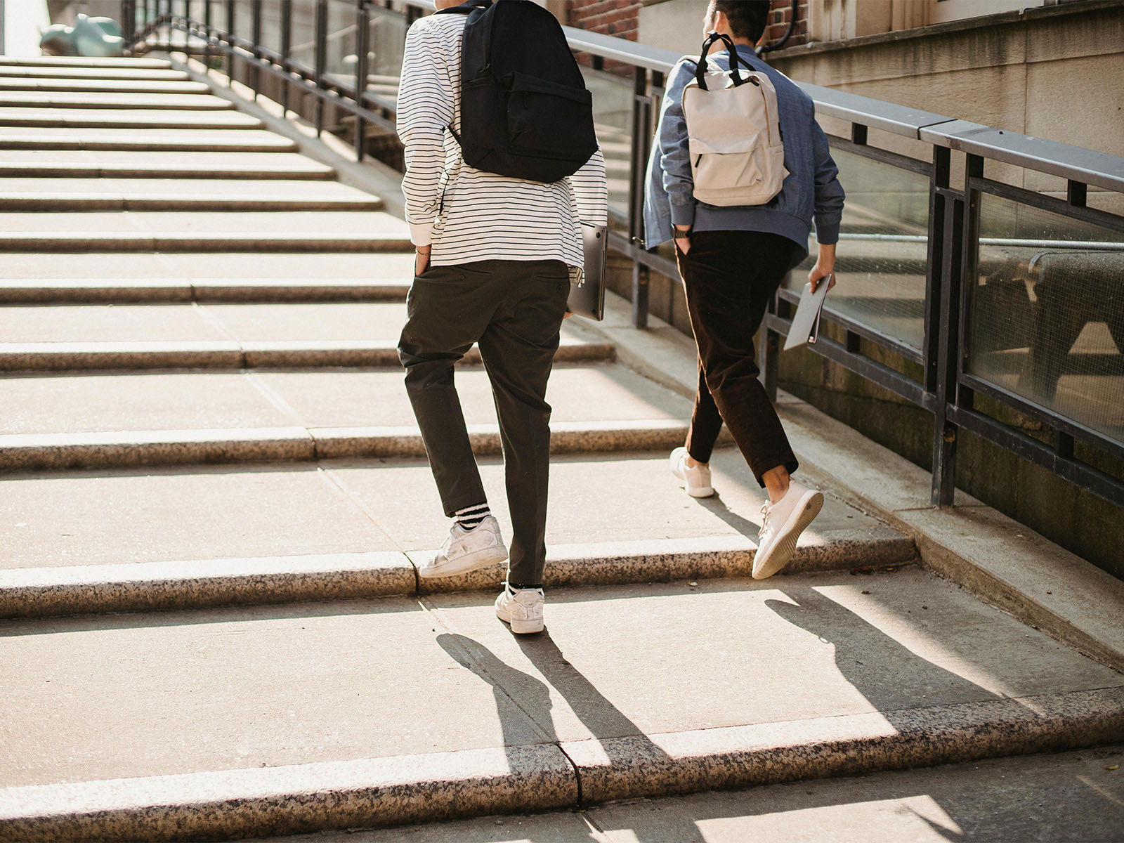 Warren UC - Private International College Consulting - Summer Prep- Five Quick Steps to Enhance Your College Application blog post - Two students with backpacks walking up stone steps - Pexels Armin Rimoldi