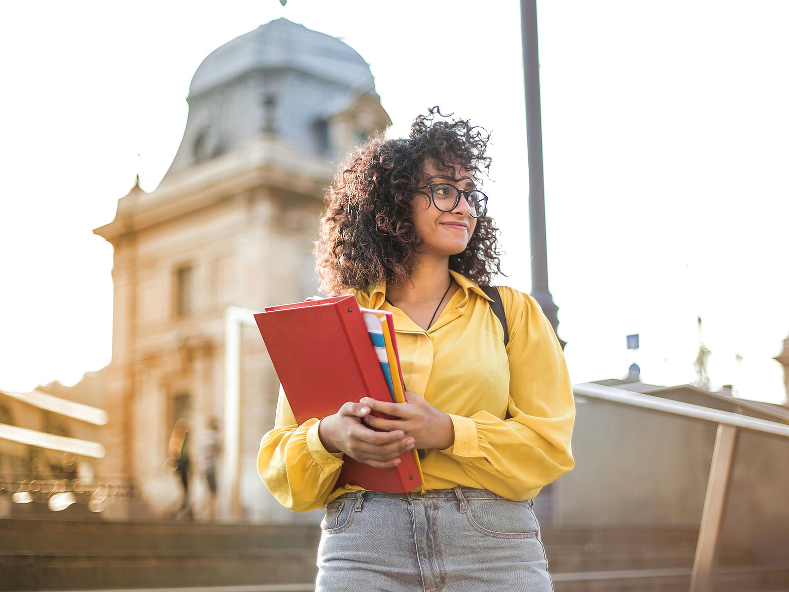 Warren UC - Private International College Consulting - Impact of Campus Culture blog post - Smiling woman holding books - Pexels Andrea Piacquadio