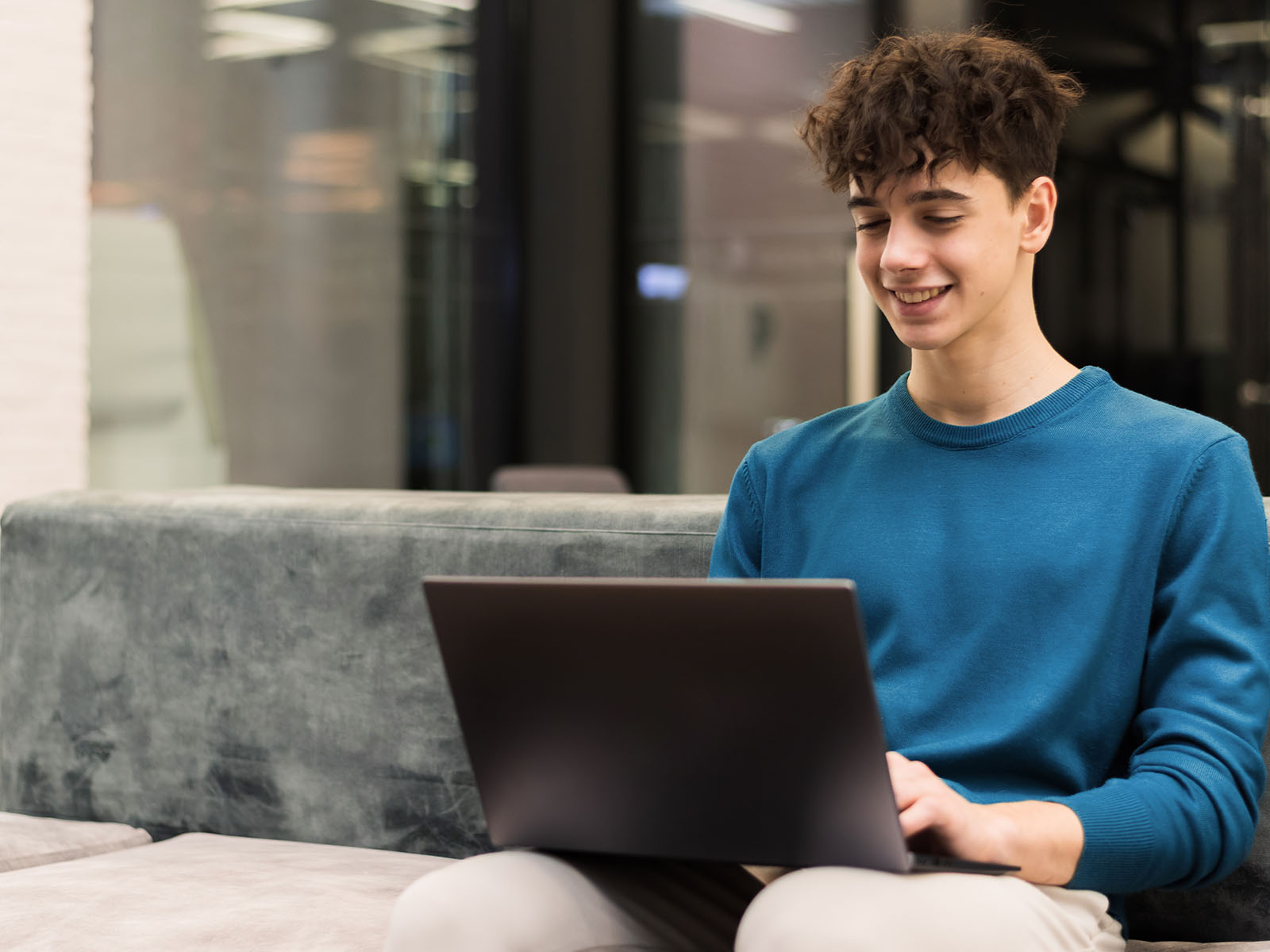 Warren UC - Private International College Consulting - Application Strategies for the US, UK, and Canada webinar - Young man smiling at laptop screen - Freepik