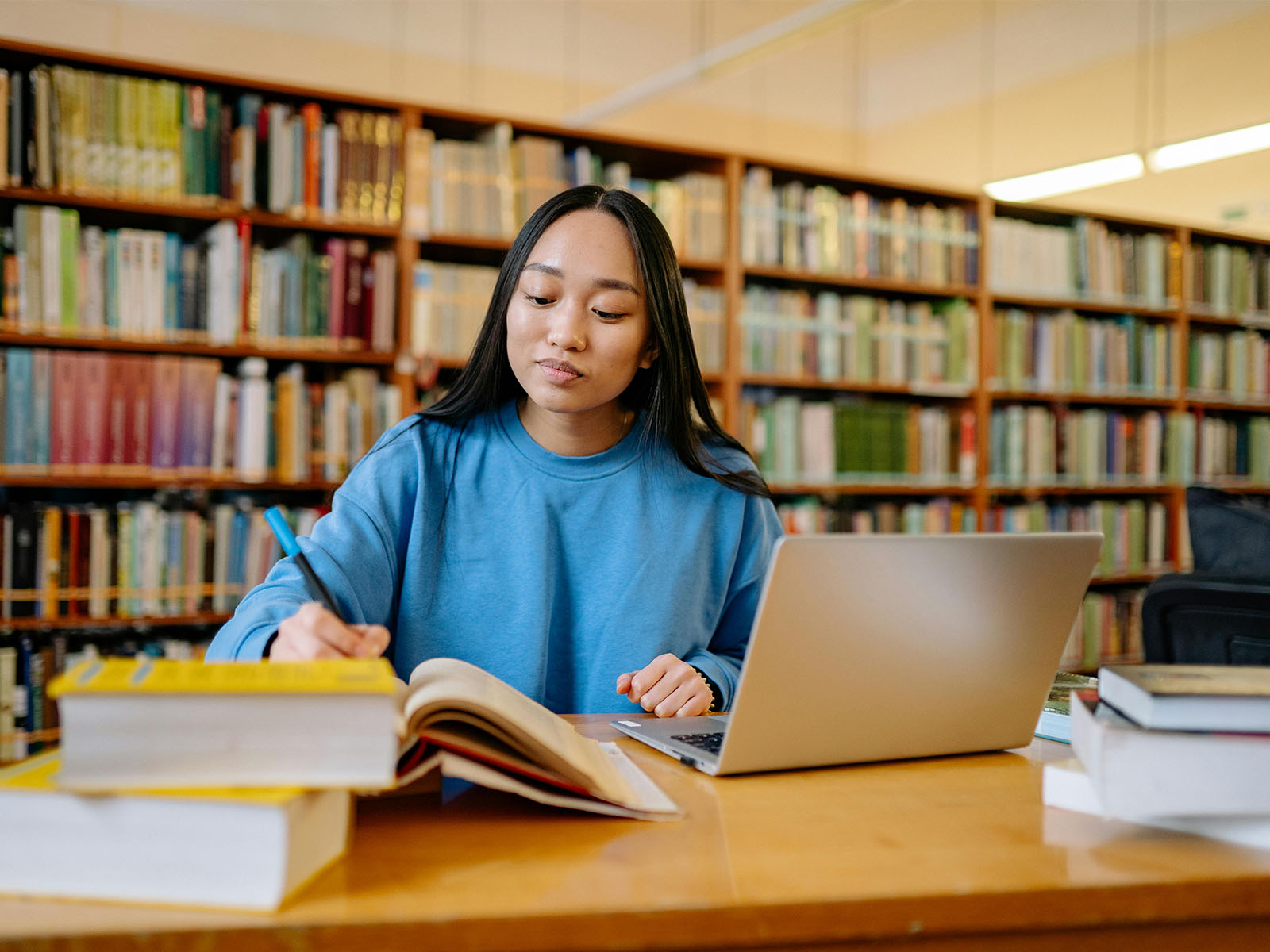 WarrenUC - Private International College Consulting - Applying to Computer Science Programs- How to Prepare for Success blog post - Woman in Blue Long Sleeve Shirt Sitting at the Table Writing - Pexels Yan Krukau