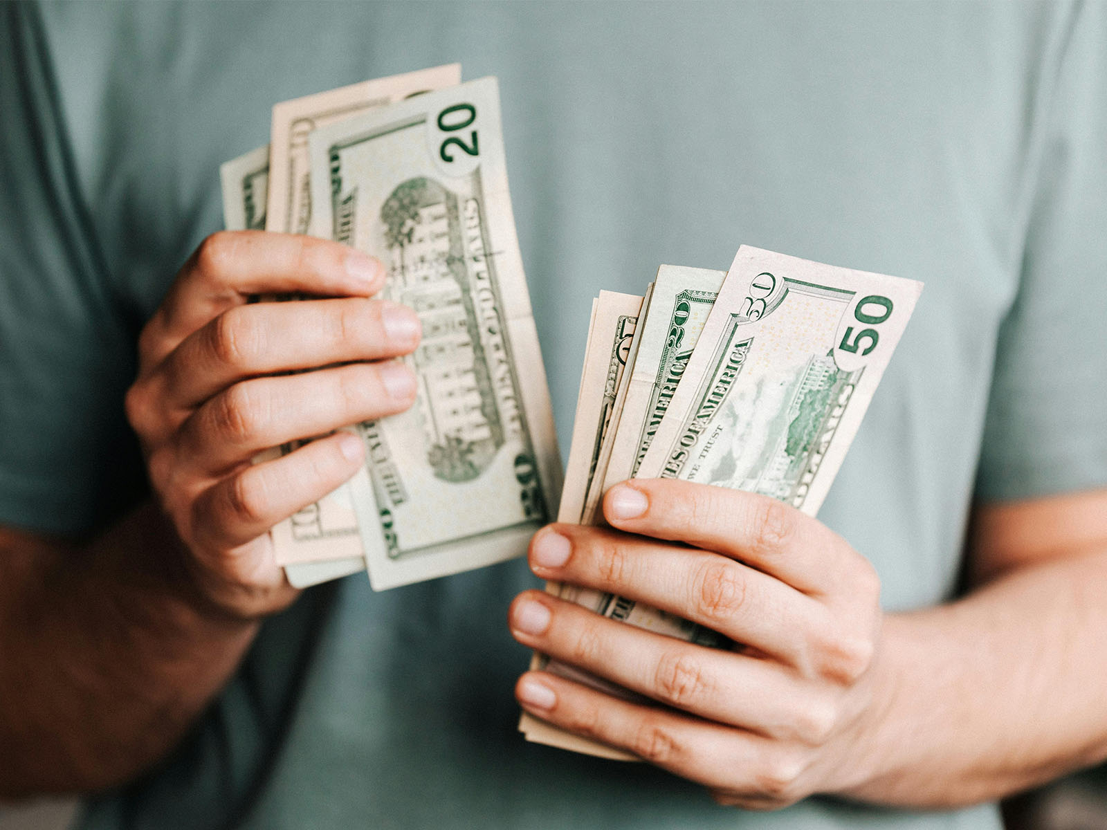 Warren UC - Private International College Consulting - Can International Students Get Financial Aid in the U.S.? Here’s the Truth blog post - Person in blue shirt with US money - Pexels Kaboompics.com