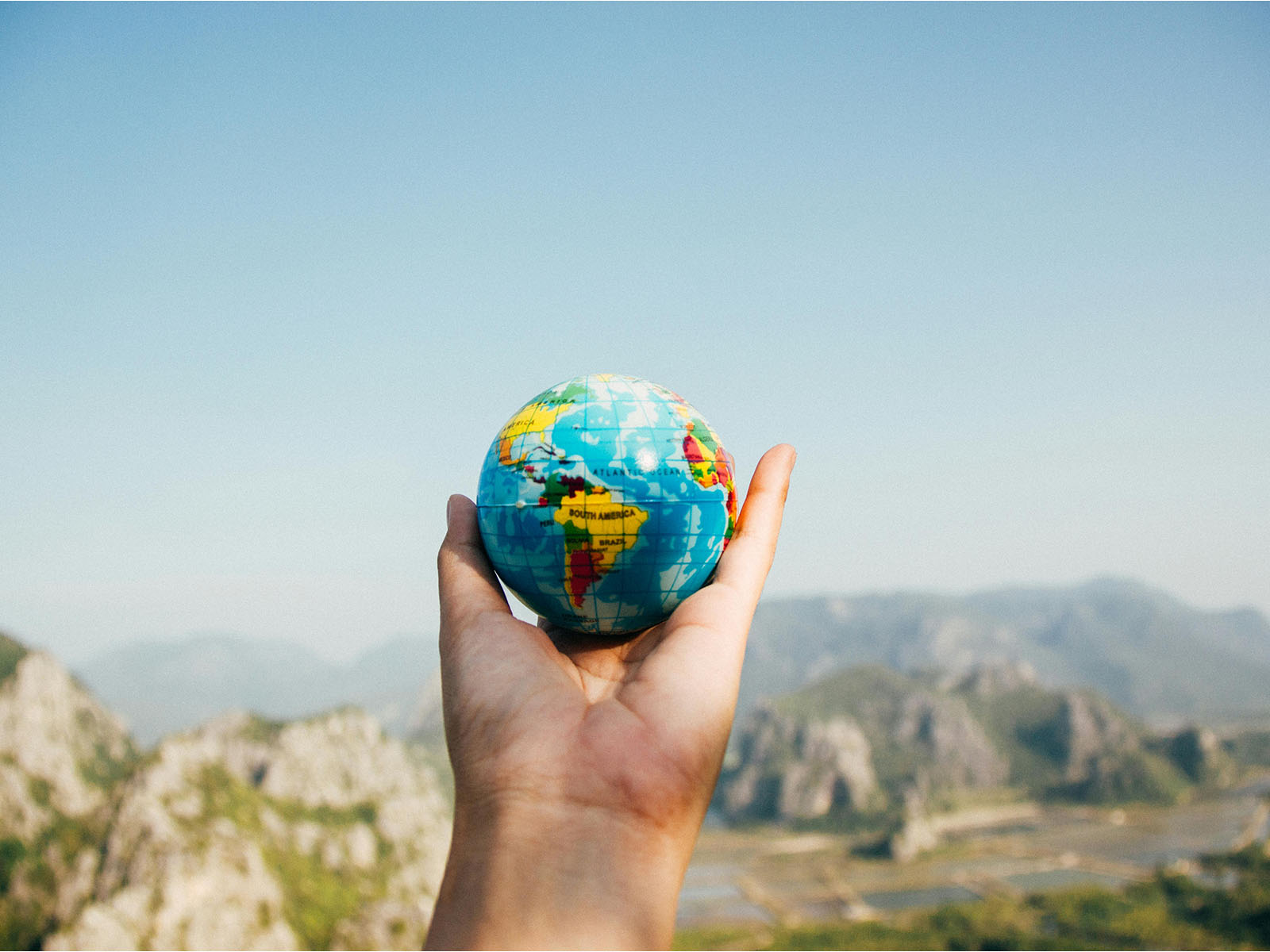 Warren UC - Private International College Consulting - Letter to US Congress backing int’l education attracts 4.2k supporters post - Person Holding World Globe Facing Mountain - Pexels Porapak Apichodilok